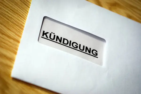 Bir zarfın sembol fotoğrafı. İçinde iş ve özel amaçlar için bir fesih mektubu var. Genel olarak Alman yazıları Kuendigung.