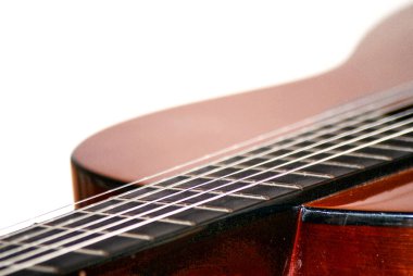 Klasik akustik gitarın sanatsal yakın çekimi. Telleri, ahşap dokuyu ve kıvrımları gösteriyor. Yaratıcı veya editörel kullanım için soyut müzik konsepti ve enstrüman ayrıntıları