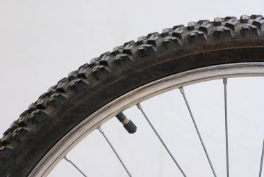 Lastiğin üzerindeki bisiklet valfinin yakın çekimi, izole edilmiş ya da doğal ayarda. Bisiklet ekipmanlarını, lastik basıncını ve düzenli motor bakımını temsil ediyor. Metin uzayı