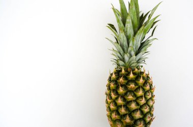 Beyaz arka planda izole edilmiş tek bir ananasın stüdyo çekimi. Gıda, sağlık, tropikal meyve ve metin veya tasarım için alanı olan reklam kavramları için temiz ürün imajı