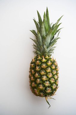 Beyaz arka planda izole edilmiş tek bir ananasın stüdyo çekimi. Gıda, sağlık, tropikal meyve ve metin veya tasarım için alanı olan reklam kavramları için temiz ürün imajı
