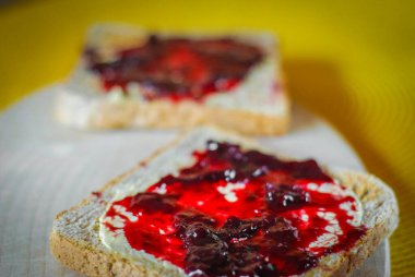 Lezzetli kahvaltı tostu, canlı çilek reçeli, taze meyve aromalı ve rahat bir sabah yemeği konsepti sergiliyor.