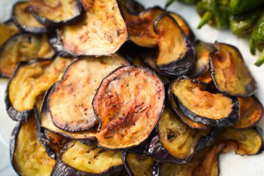 Akdeniz aperatifi olarak servis edilen kızarmış patlıcan dilimleri. Kıtır kıtır bir doku, sıcak bir ton ve lezzetli bir başlangıç.