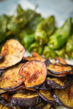 Akdeniz aperatifi olarak servis edilen kızarmış patlıcan dilimleri. Kıtır kıtır bir doku, sıcak bir ton ve lezzetli bir başlangıç.