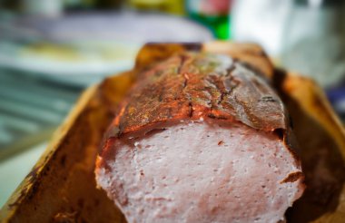 Leberkaese, sıcak bir mutfak ortamında taze pişmiş rulo köfte, altın kabuğunu ve sulu dokusunu sergiliyor. Geleneksel doyurucu yemekler için mükemmel.