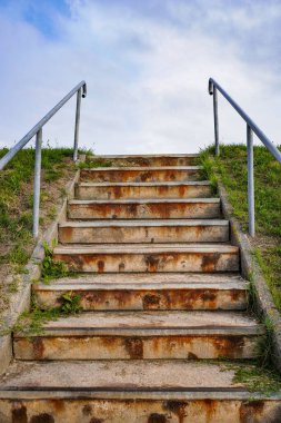Yukarı doğru çıkan boş bir merdiven, temiz mimari çizgiler ve insansız huzurlu bir atmosfer, izleyiciyi yükselmeye davet ediyor.