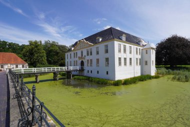 Dornum, Doğu Frizya, Almanya. 15 Temmuz 2025. Dornum 'daki barok demirli kale şimdi klasik bir 17. yüzyıl cephesi, bir hendeğe köprü ve Doğu Frizya' nın zengin mimari detaylarına sahip.