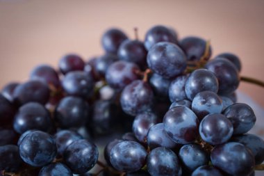 Yakın plan mavi üzümler sulu dokularını ve doğal canlı renklerini sergiliyor. Üzüm bağı ya da sağlıklı yemek temaları için mükemmel.