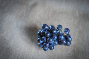Yakın plan mavi üzümler sulu dokularını ve doğal canlı renklerini sergiliyor. Üzüm bağı ya da sağlıklı yemek temaları için mükemmel.