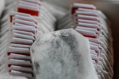 Sıraya dizilmiş çeşitli hazır çay poşetlerini bir kutuda kapat. İçecek çeşitliliği, kolaylık ve çay kültürü çizimleri için