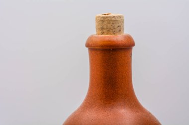 Beyaz arka planda kahverengi kilden bir şişenin gerçek fotoğrafı. Kırsal seramik tasarım seramik işçilik ve minimalist ürün tarzı sergileniyor.
