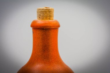 Beyaz arka planda kahverengi kilden bir şişenin gerçek fotoğrafı. Kırsal seramik tasarım seramik işçilik ve minimalist ürün tarzı sergileniyor.