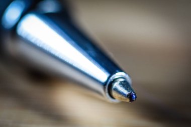 Metal enstrüman yüzeyi ve hassasiyetinin ince detaylarını gösteren tükenmez kalem ucu aşırı yakın çekim