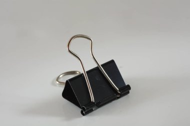 Minimalist ofis motifi beyaz bir yüzeyde siyah ataçları gösterir, metin veya düzen entegrasyonu için geniş bir alanı vardır