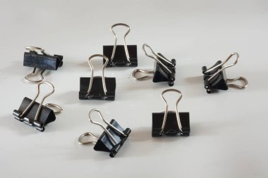 Minimalist ofis motifi beyaz bir yüzeyde siyah ataçları gösterir, metin veya düzen entegrasyonu için geniş bir alanı vardır