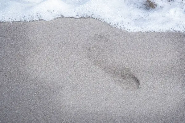 Kumsalın kumlarında ayak izleri.