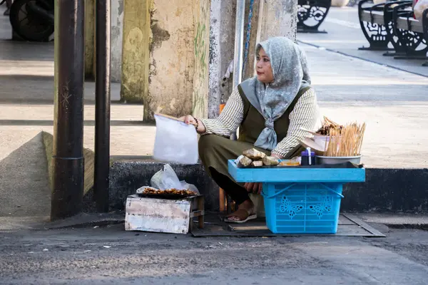 Yogyakarta, Endonezya - 11 Eylül 2024: Malioboro 'daki satay satıcısı Endonezya sokak yemeklerinin zengin geleneğini ve gelişen yerel mutfak ekonomisini örnek göstermektedir.