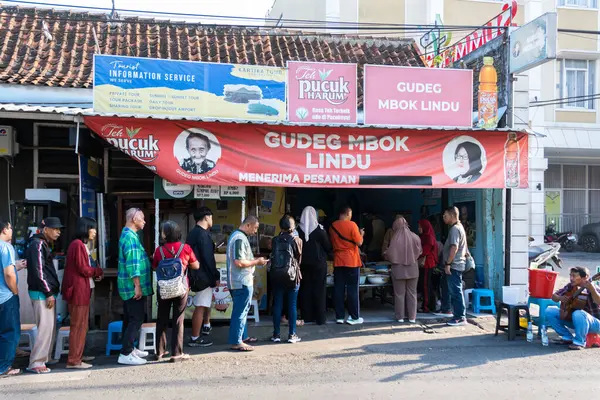 Yogyakarta, Endonezya - 11 Ekim 2024: İnsanlar, özgün Jogjakarta lezzetleriyle ünlü geleneksel bir Nasi Gudeg yemeği olan efsanevi Gudeg Mbok Lindu 'nun tadına bakmak için Malioboro yakınlarında uzun bir kuyruk oluşturuyor.