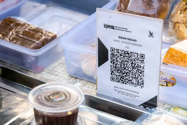Yogyakarta, Endonezya - 11 Ekim 2024: Küçük bir sokak kenarı pasta dükkanı, küçük işletmeler için kolay ve pratik bir ödeme yöntemi sunarak, Qris üzerinden nakit ödemeleri kabul ediyor