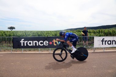 Gevrey-Chambertin, Fransa 5 Temmuz 2024. Groupama-FDJ 'den bir sürücü 2024 Fransa Turu' nun yedinci sahnesinde üzüm bağlarında bir seyircinin yanından hızla geçiyor.