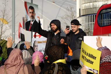 Londra / İngiltere 20 Ocak 2020. Bir protestocu, İngiltere Afrika Yatırım Zirvesi sırasında eski Mısır Cumhurbaşkanı Muhammed Morsi 'nin Londra' da gerçekleştirdiği ve halefi Abdül Fatah El-Sisi 'nin konuşma yaptığı bir protesto sırasında çekilmiş bir resmini elinde tutuyor.