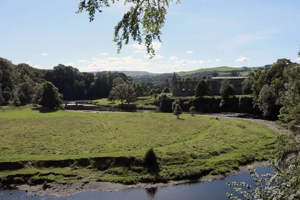 stock image 20 September 2021. View of the ruins of Bolton Priory, North Yorkshire, with the River Wharfe in the foreground