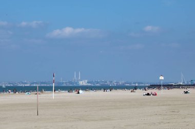 Deauville / France  September 14, 2019. A view across the sands of Deauville beach and the English Channel towards the industrial area of Le Havre clipart