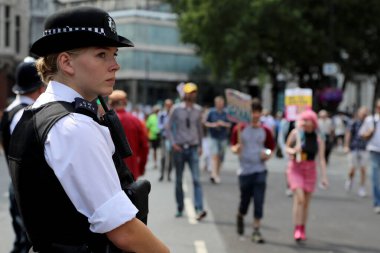 Londra, İngiltere 13 Temmuz 2018. Bir kadın polis memuru, ABD Başkanı Donald Trump 'ı Londra şehir merkezinde protesto etmek amacıyla düzenlenen gösteriden önce olay yerini inceliyor.