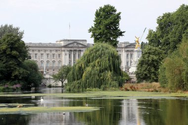 Londra / İngiltere - 26 Temmuz 2018. Buckingham Sarayı 'nın manzarası İngiliz hükümdarının evi, Londra' nın merkezindeki St. James Park 'ın ağaçları arasında.