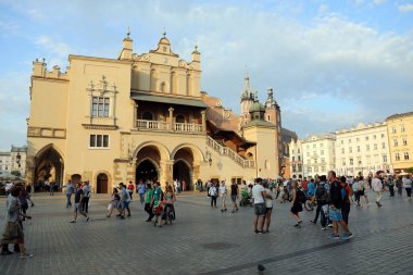 25 Ağustos 2017 'de Polonya' nın Eski Krakow kentinin ana meydanı Rynek Glowny 'de yürüyen turistler görülüyor. Kuaför salonu ortada, arka planda Aziz Mary Bazilikası var..