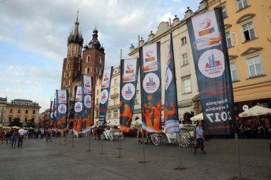 25 Ağustos 2017 'de Polonya' nın Krakow kentinin ana meydanı Rynek Glowny 'de düzenlenen 2017 Avrupa Erkekler Voleybol Şampiyonası' nın reklamını yapan bayraklar. Arka planda Aziz Mary Bazilikası var..