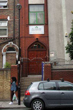 30 Temmuz 2014 Çarşamba günü Londra Finsbury Park 'taki Finsbury Park camisi olarak da bilinen Kuzey Londra Merkez Camii' nin girişinde türban takan bir kadın görülüyor.