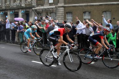 Marcel Wyss of IAM Cycling (no. 199) and Frank Schleck of Trek Factory Racing (no. 161) and Maxim Iglinkskiy of Astana Pro Team (no. 45) race through the rain along Lower Thames Street in London, on Stage 3 of the 2014 Tour de France on Monday 7 July clipart