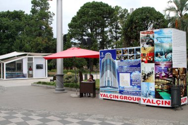 Bir satış asistanı, Batumi, Gürcistan 'da bir Türk firması olan Yaln Grup tarafından inşa edilen dairelerin standında müşterileri beklerken cep telefonuna bakıyor.