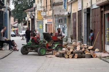 Taşınabilir testere makinesi kullanan bir adam, Bitola, Kuzey Makedonya sokaklarında küçük bir seyirci kitlesini kendine çekiyor