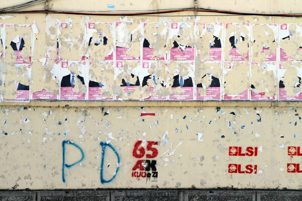 Полуразорванные предвыборные плакаты и граффити с всеобщих выборов в июне 2013 года на стене в Берате, Албания в среду 4 сентября 2013 года