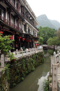 Restaurants line the canal in Yangshuo, south-west China clipart