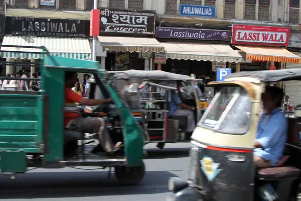 Trafik akışı Jaipur, Hindistan 'da Lassi satan dükkanların önünden geçiyor