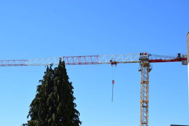 a red crane in front of blue sky clipart