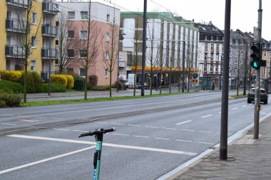 Frankfurt 'ta bir benzin istasyonu ve bir escooter ile şehir caddesi.