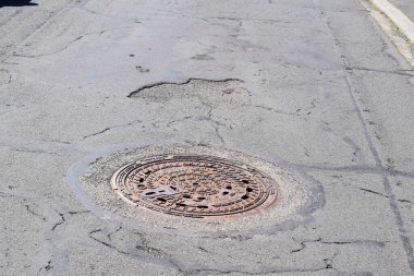 Sokaktaki paslı metal delik.