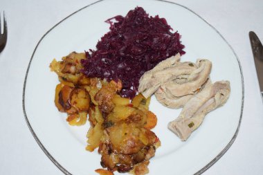 Kızarmış patates, domuz derisi ve kırmızı lahana.