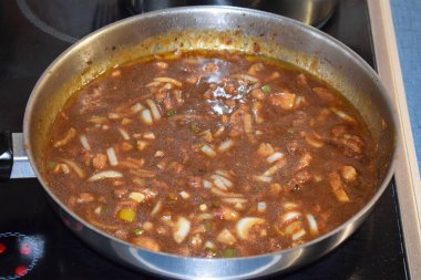 Gulaş tavada kızartılıyor, soslu.