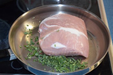 Tavada pişmeye hazır çiğ domuz eti.