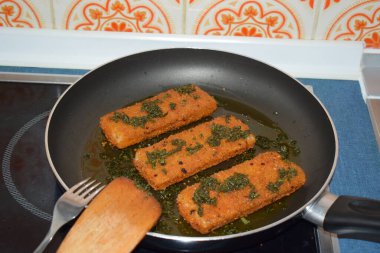 Kızartma tavasında bir sürü otlu balık.