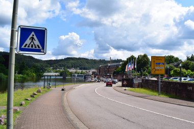 Almanya 'nın Mettlach şehrinde Saar boyunca bir gemi ve birkaç arabalı bir cadde.