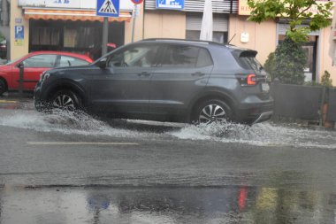 Şiddetli yağmur ve sel altında bir araba