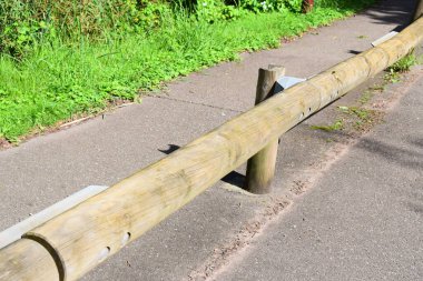 Parkta çit var, yolun yanında.