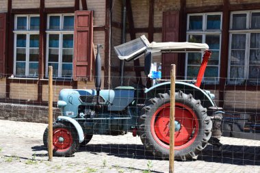 old tractor in front of a half-timbered building