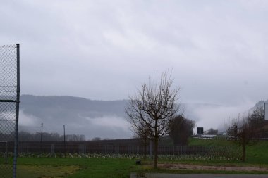 fog on a hill in a german village in autumn clipart